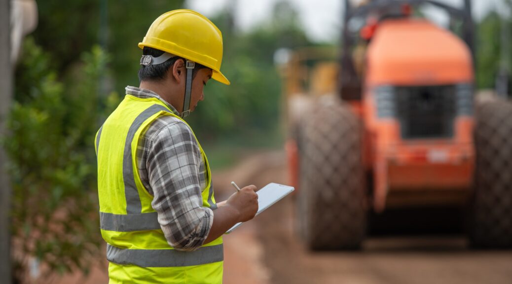 A civil engineer inspects road roller to build asphalt road